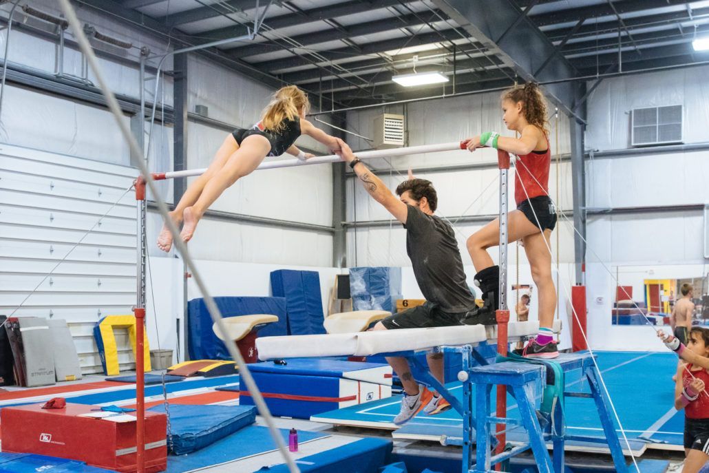 A group of people are doing gymnastics in a gym.
