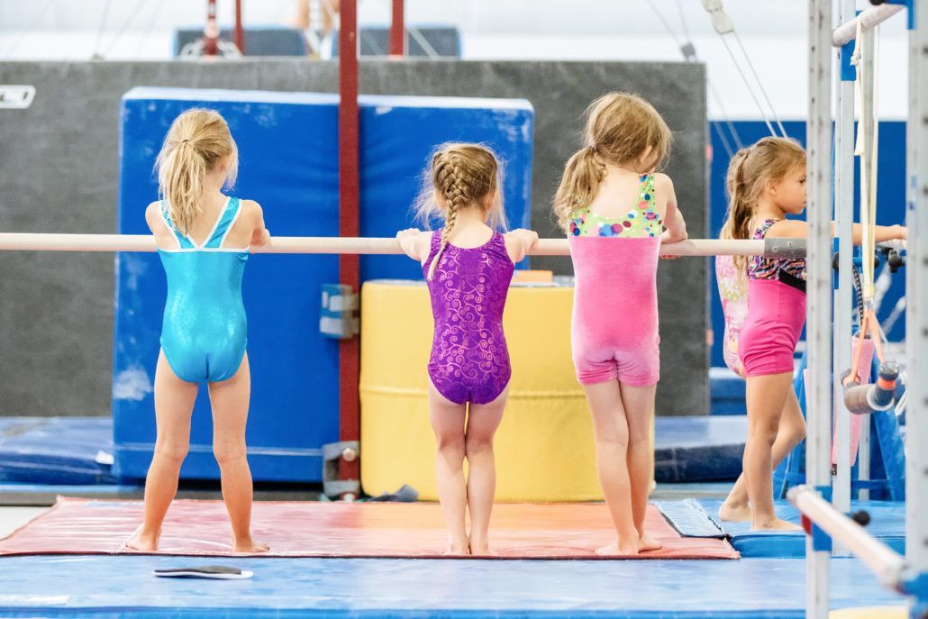 A group of young girls are doing gymnastics in a gym.
