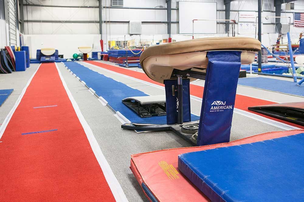 A gymnastics gym with a balance beam and a track.
