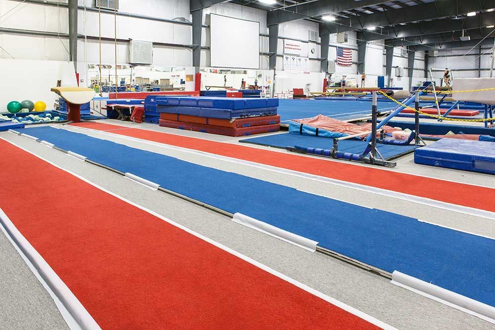 A gym with a red , white and blue track