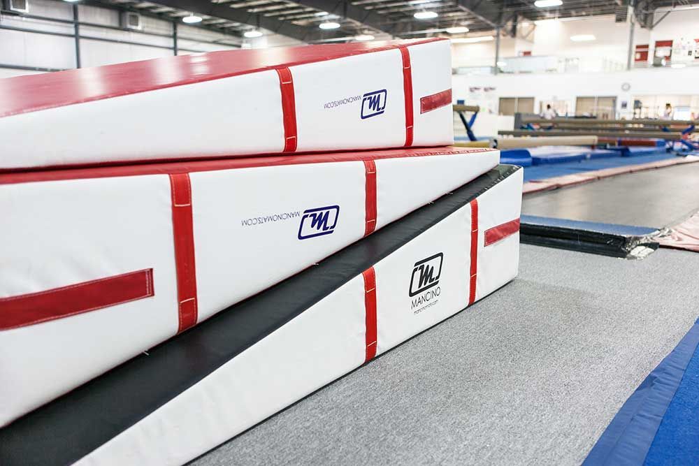 A stack of red and white foam ramps in a gym.