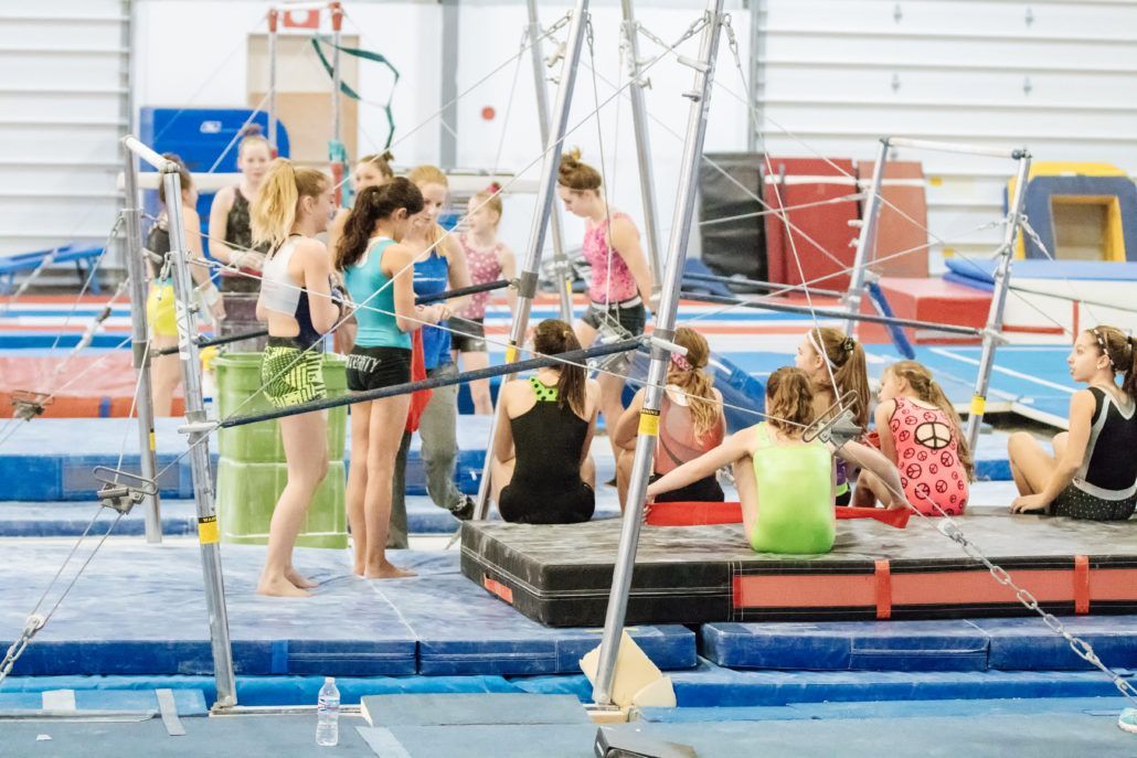A group of young girls are practicing gymnastics in a gym.