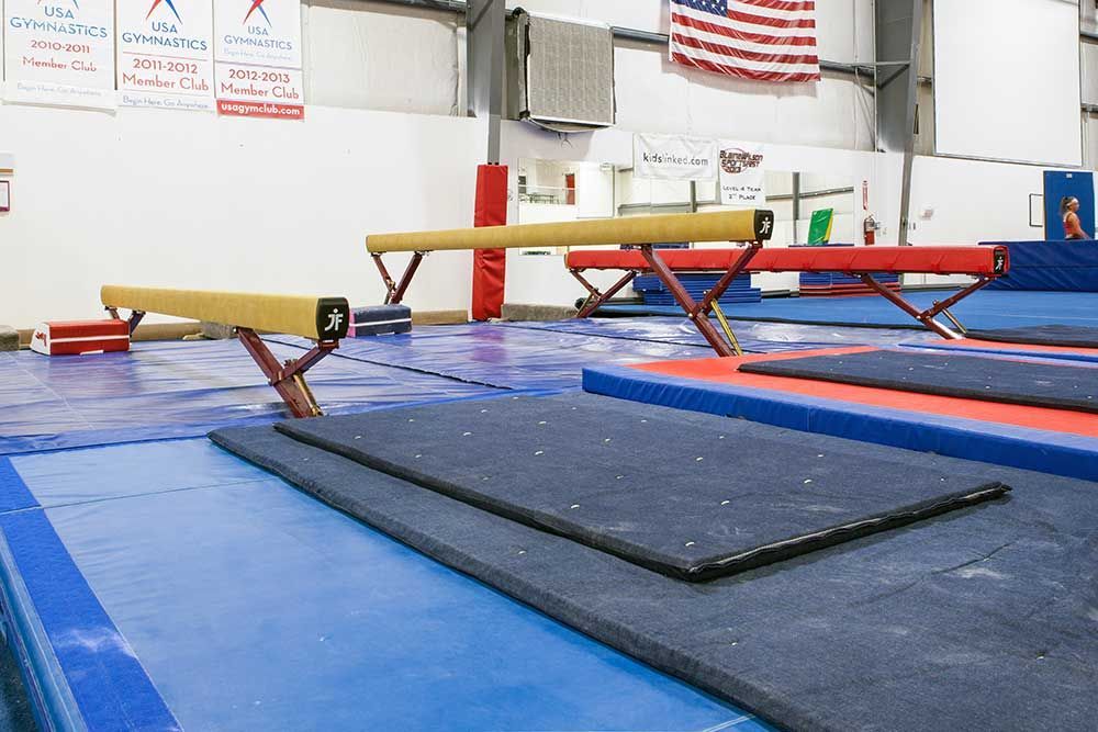 A row of balance beam in a gym with an american flag in the background