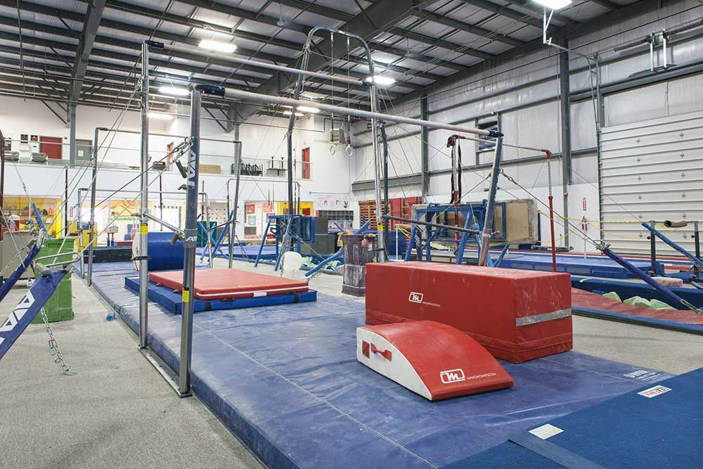 A gym with a lot of equipment and a blue mat.