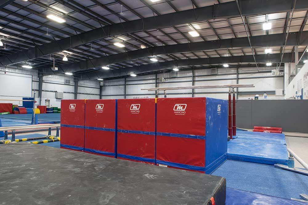 A gym with a row of red and blue boxes on the floor.