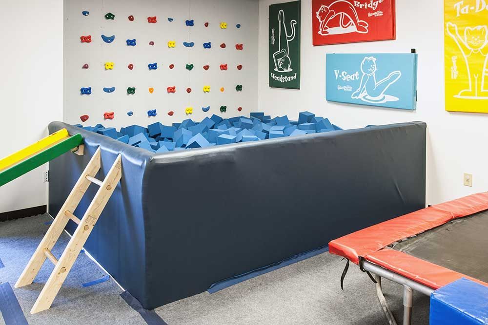 There is a trampoline and a climbing wall in the room.