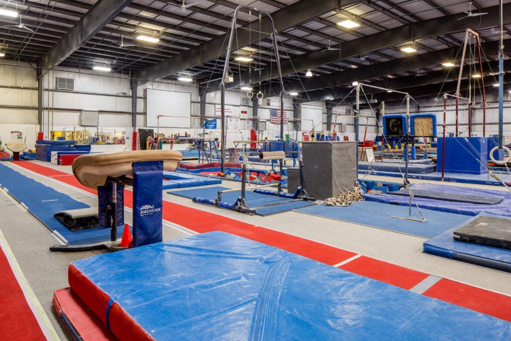 A large gym filled with lots of equipment and mats.