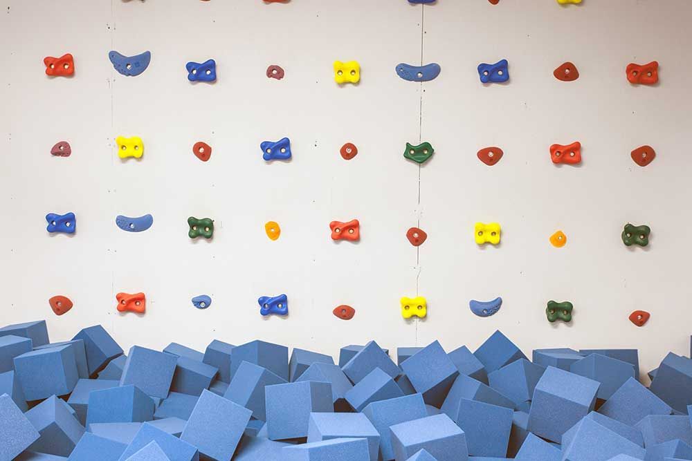 A climbing wall with foam cubes in front of it.