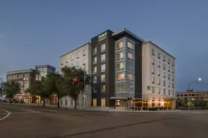 A large building is sitting on the corner of a city street.