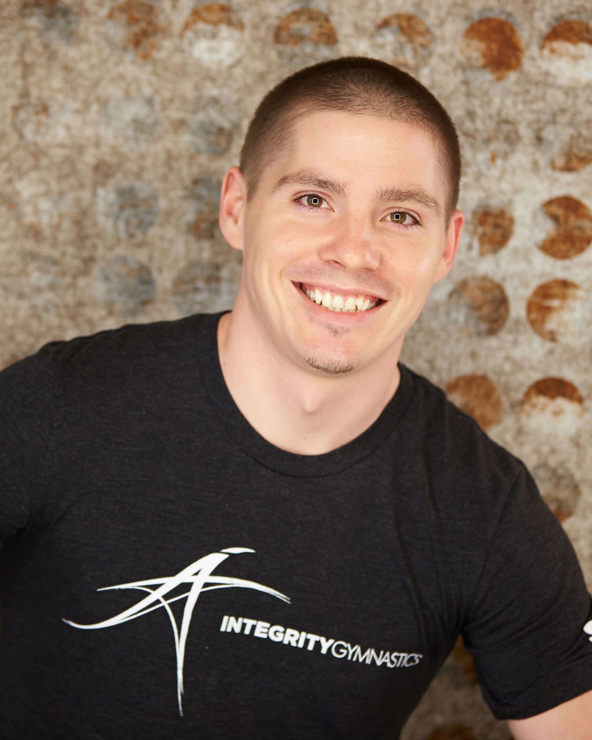 A man wearing a black shirt that says integrity gymnast