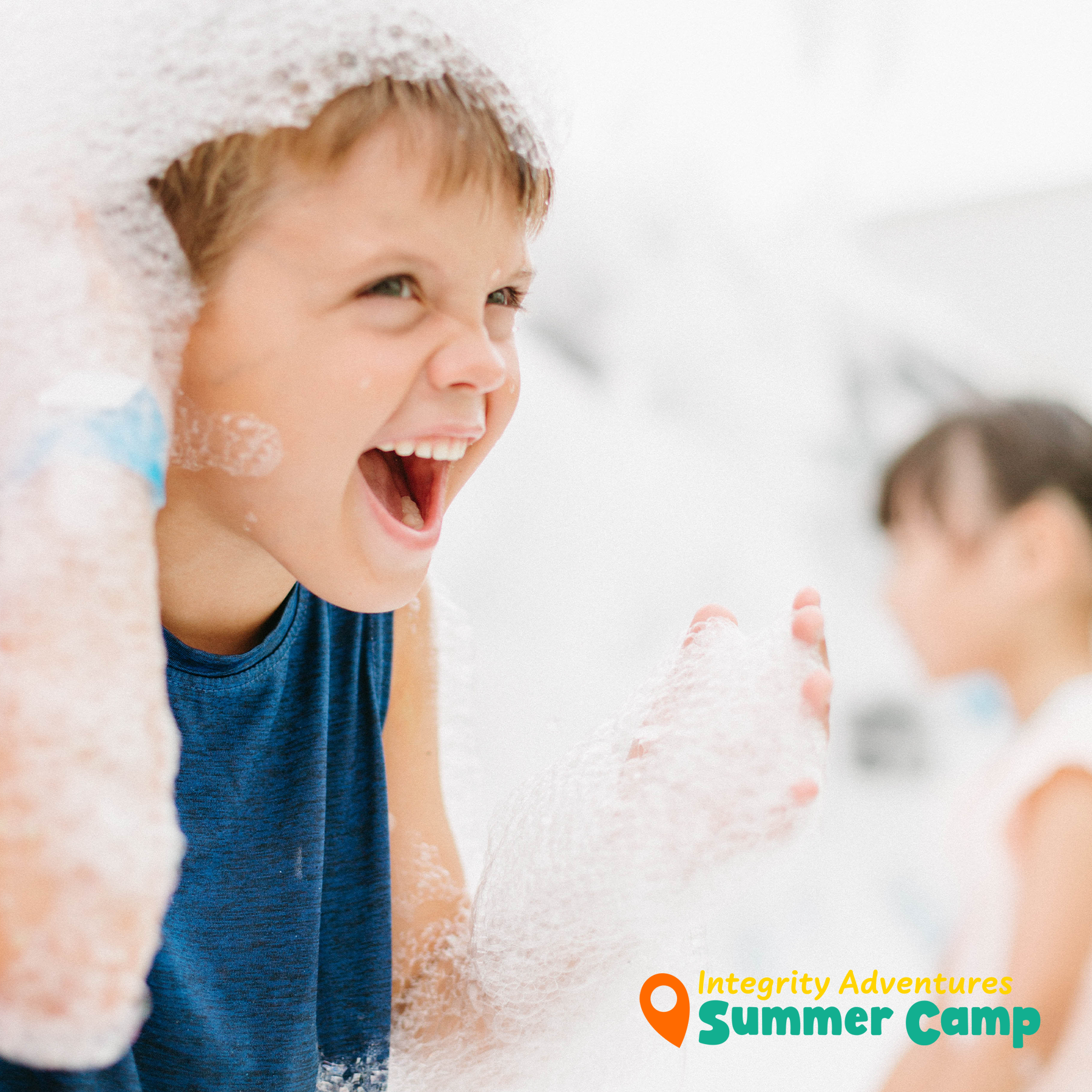 A young boy is playing with soap bubbles in a bathtub sponsored by integrity adventures summer camp