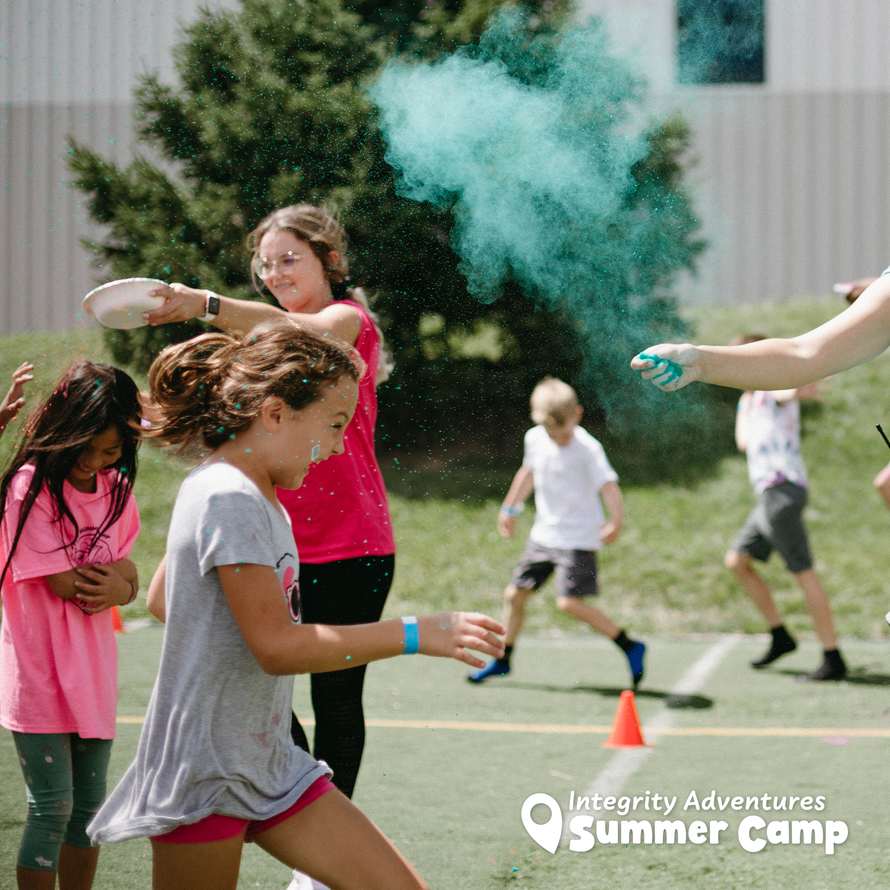 A group of children are playing frisbee in a field sponsored by integrity adventures summer camp