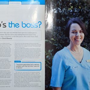 A woman in a blue scrub is smiling in a magazine.