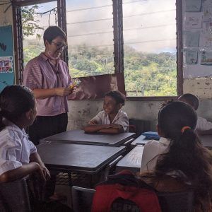 A woman is teaching a group of children in a classroom.