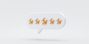 A speech bubble with five gold stars in it on a white background.