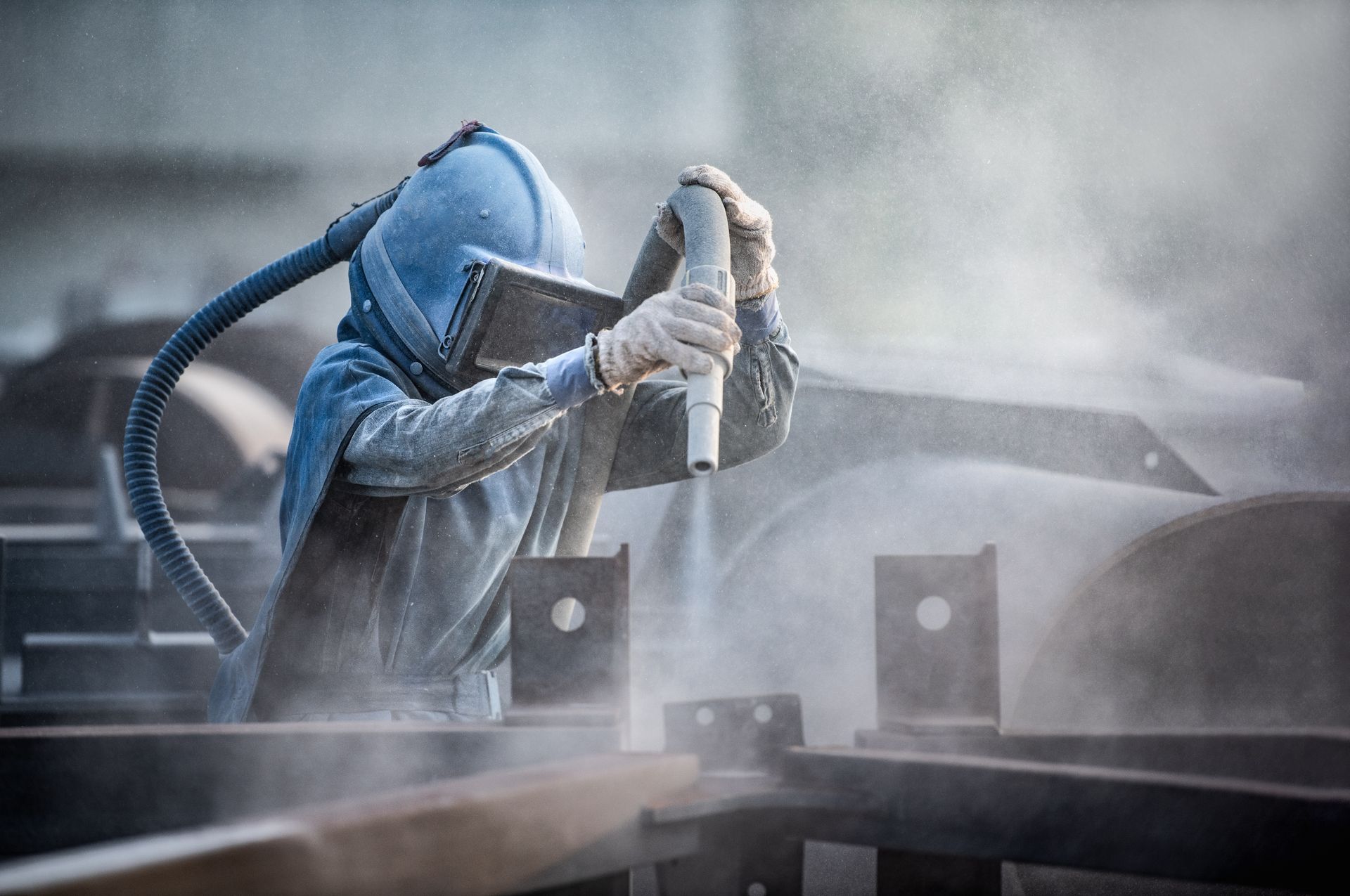 Sandblasting a piece of metal with a machine