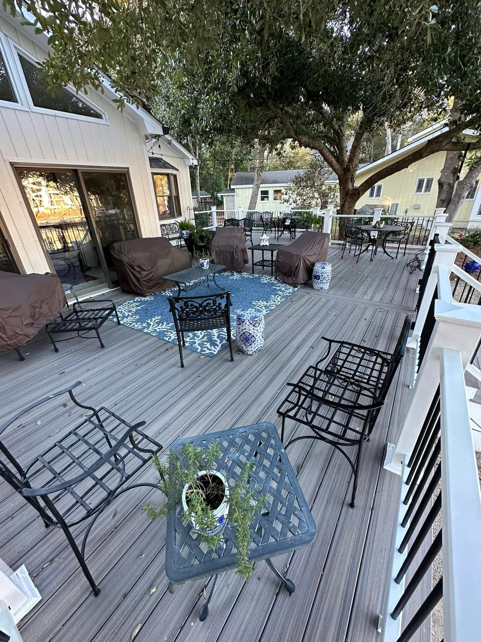A large wooden deck with a table and chairs on it.