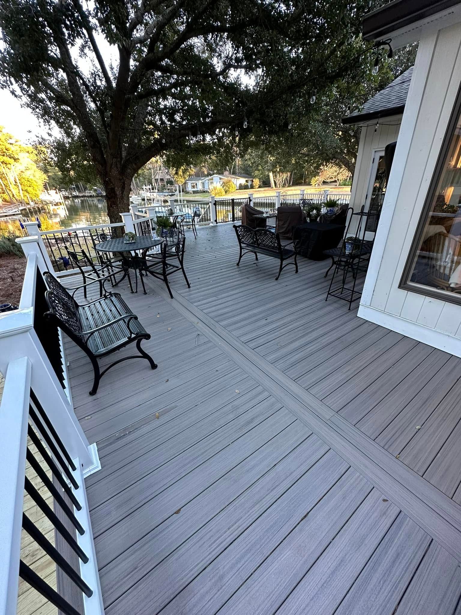 There is a large deck with tables and chairs on it.