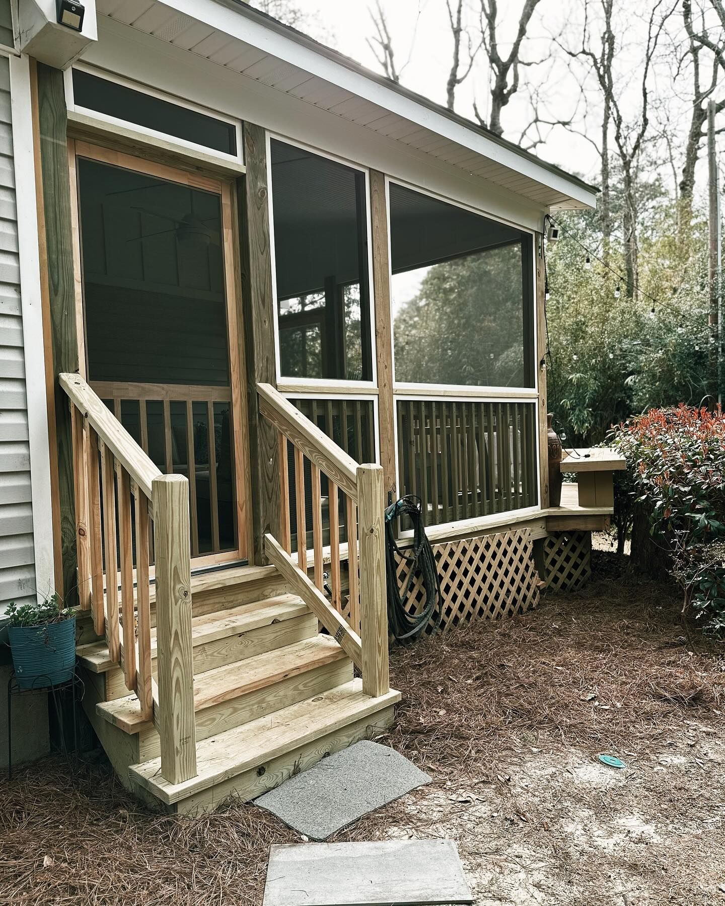 A screened in porch with stairs leading up to it is being built on the side of a house.