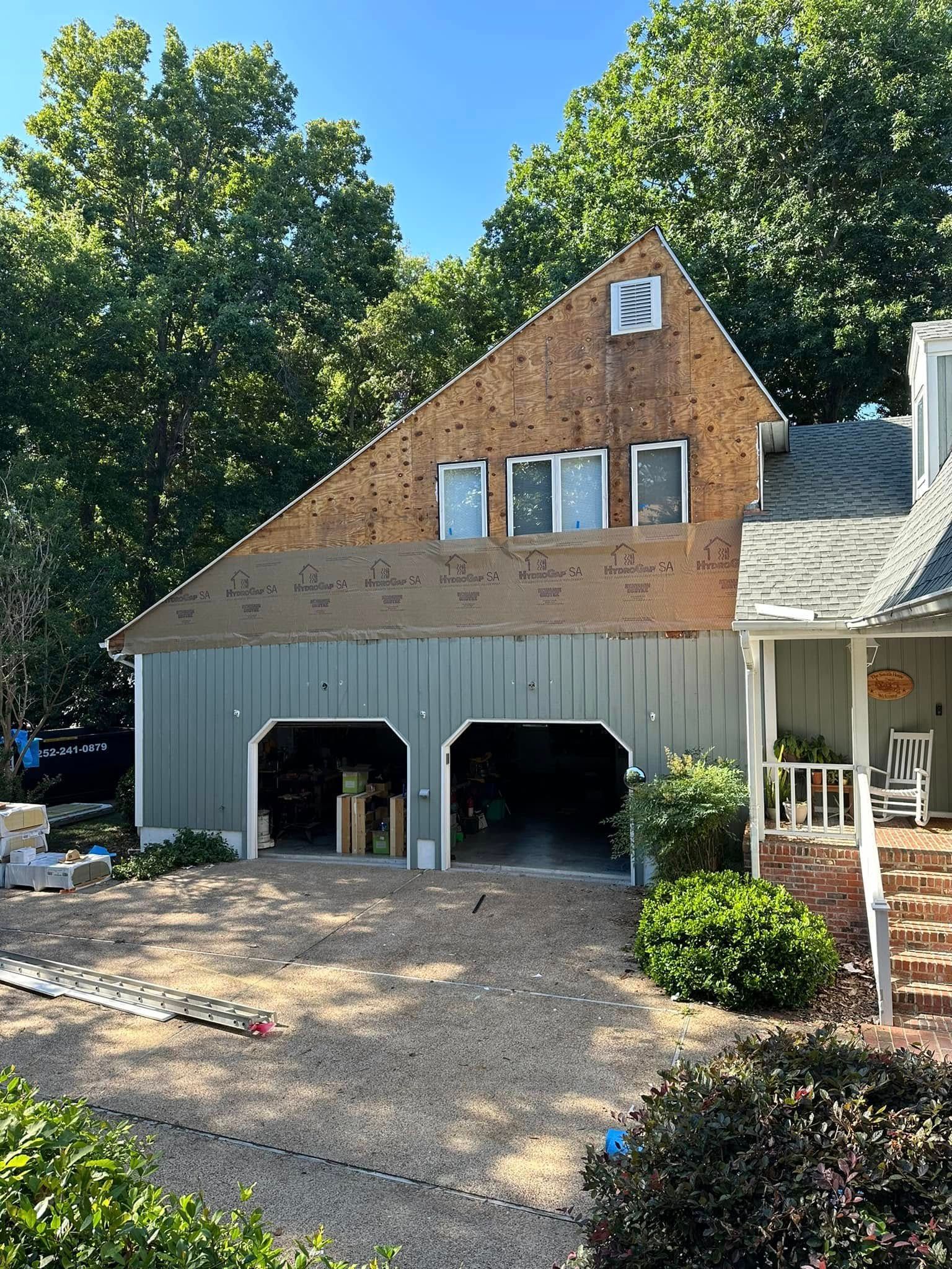 A house with a garage and a porch is being remodeled.