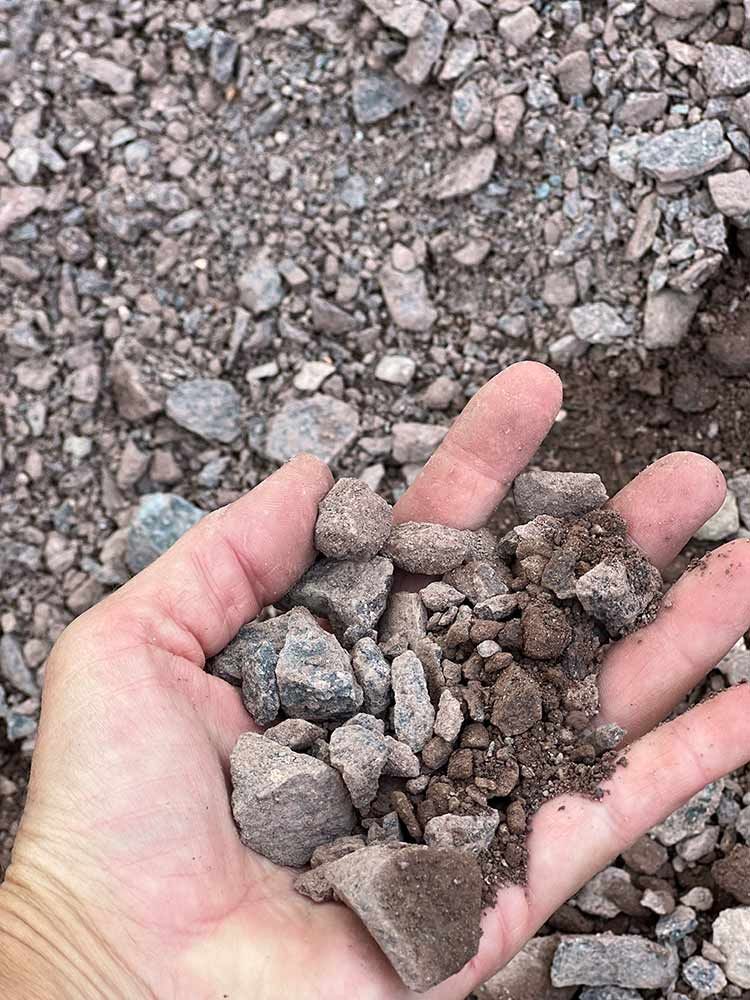 A Person Is Holding A Pile Of Rocks In Their Hand — Cooroy Landscape Supplies and Garden Centre in Eumundi, QLD