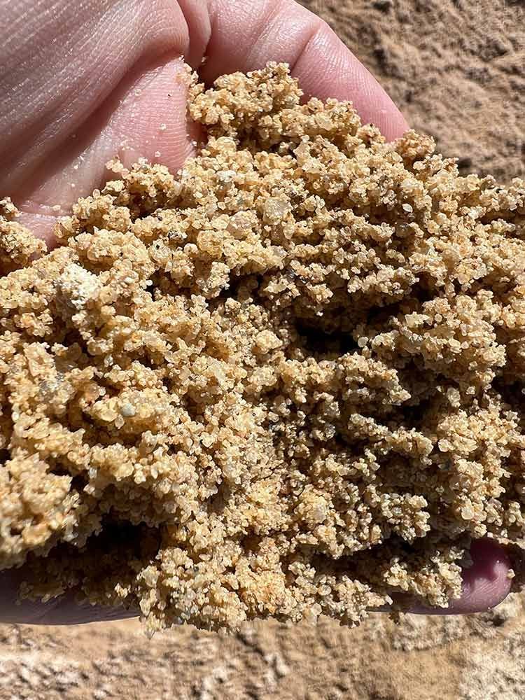 A Person Is Holding a Pile of Sands in Their Hand — Cooroy Landscape Supplies and Garden Centre in Cooroy, QLD