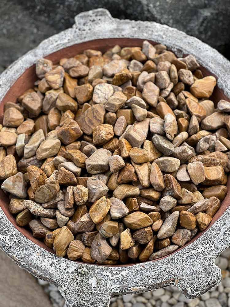 A Bowl Filled With Rocks Is Sitting On Top Of A Bird Bath — Cooroy Landscape Supplies and Garden Centre in Gympie, QLD