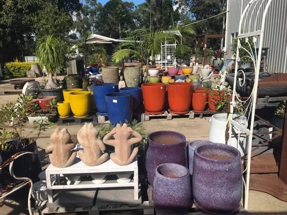 A Bunch of Pots Are Sitting on A Table in A Garden — Cooroy Landscape Supplies and Garden Centre in Cooroy, QLD