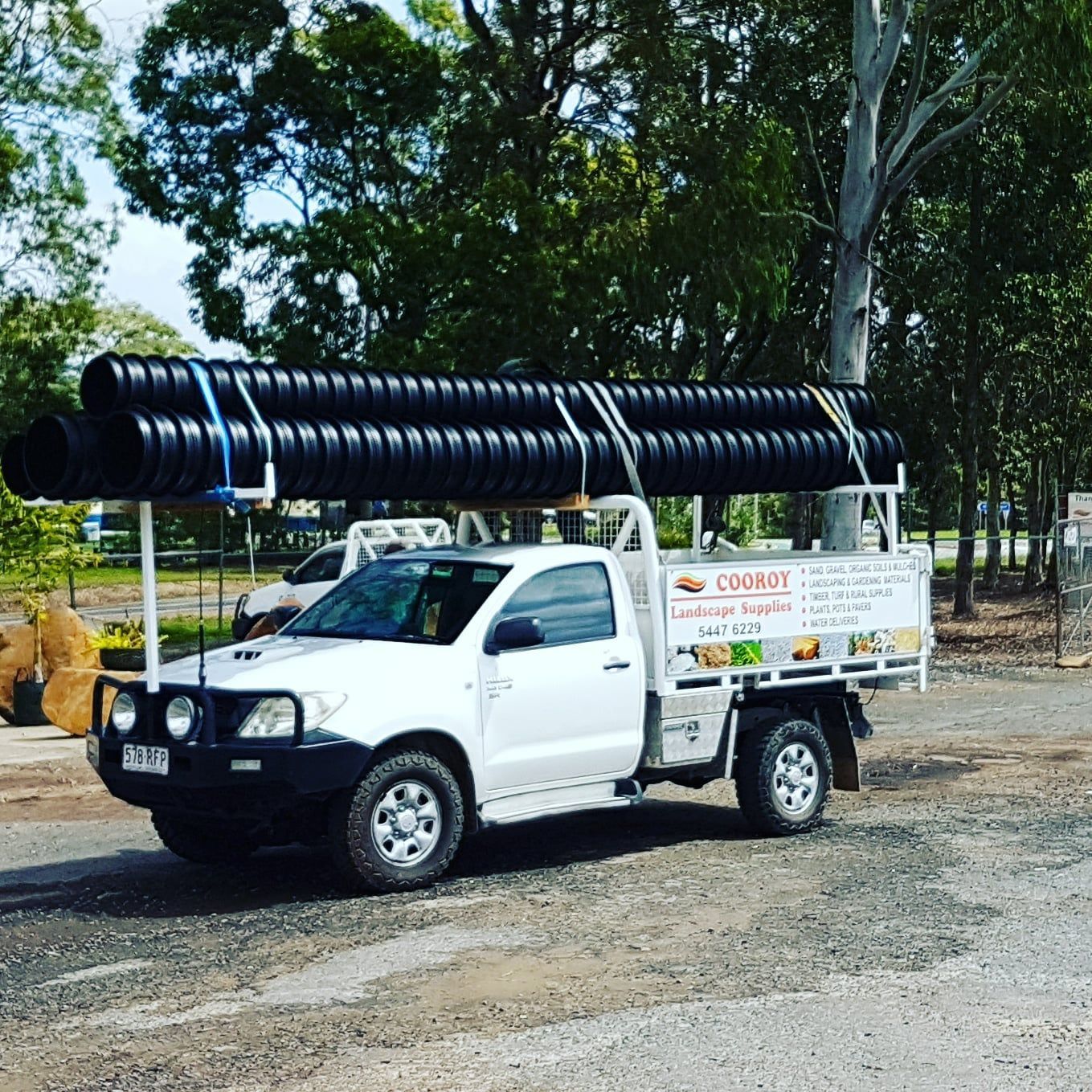 A White Ute Has Large Black Pipes On The Roof Rack — Cooroy Landscape Supplies and Garden Centre in Cooroy, QLD