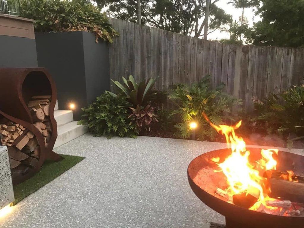 A Fire Pit In A Backyard With A Wooden Fence — Cooroy Landscape Supplies and Garden Centre in Eumundi, QLD