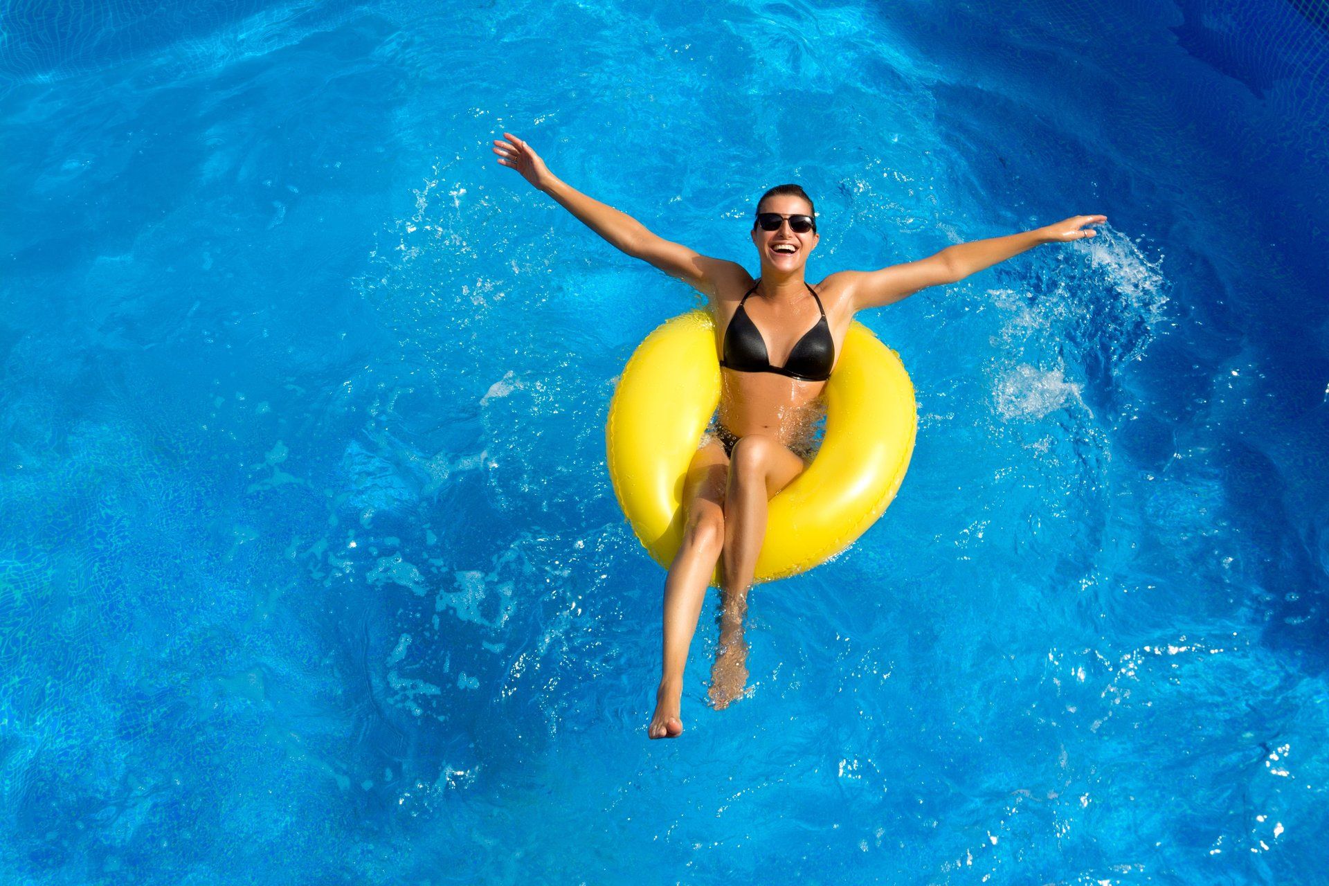 Woman in a pool with a yellow floatie