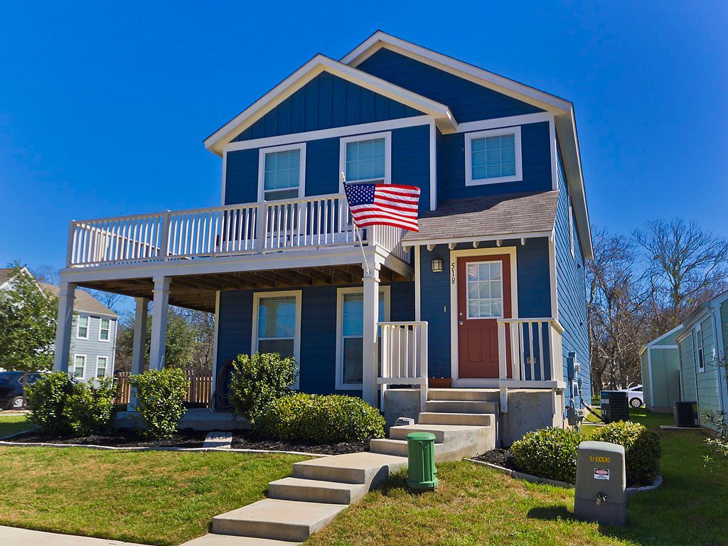 A blue house with an american flag on the porch