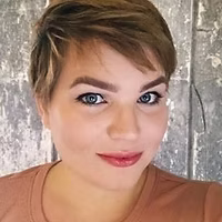 A close up of a woman 's face with short hair and blue eyes.