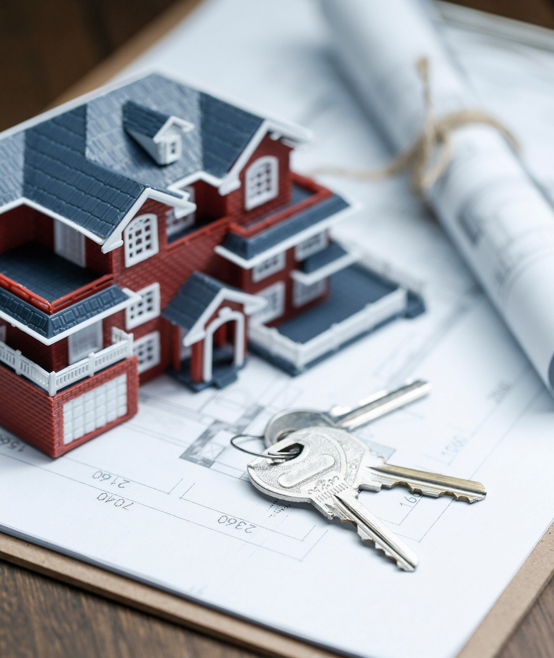 A model house and keys are on a clipboard.