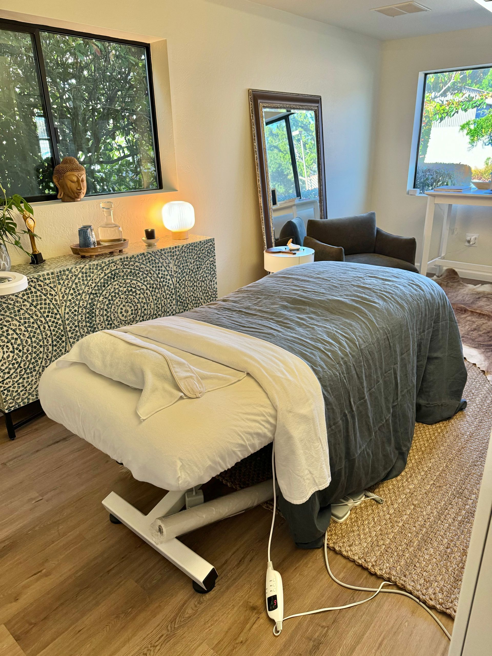 A massage table is sitting in a room next to a window.