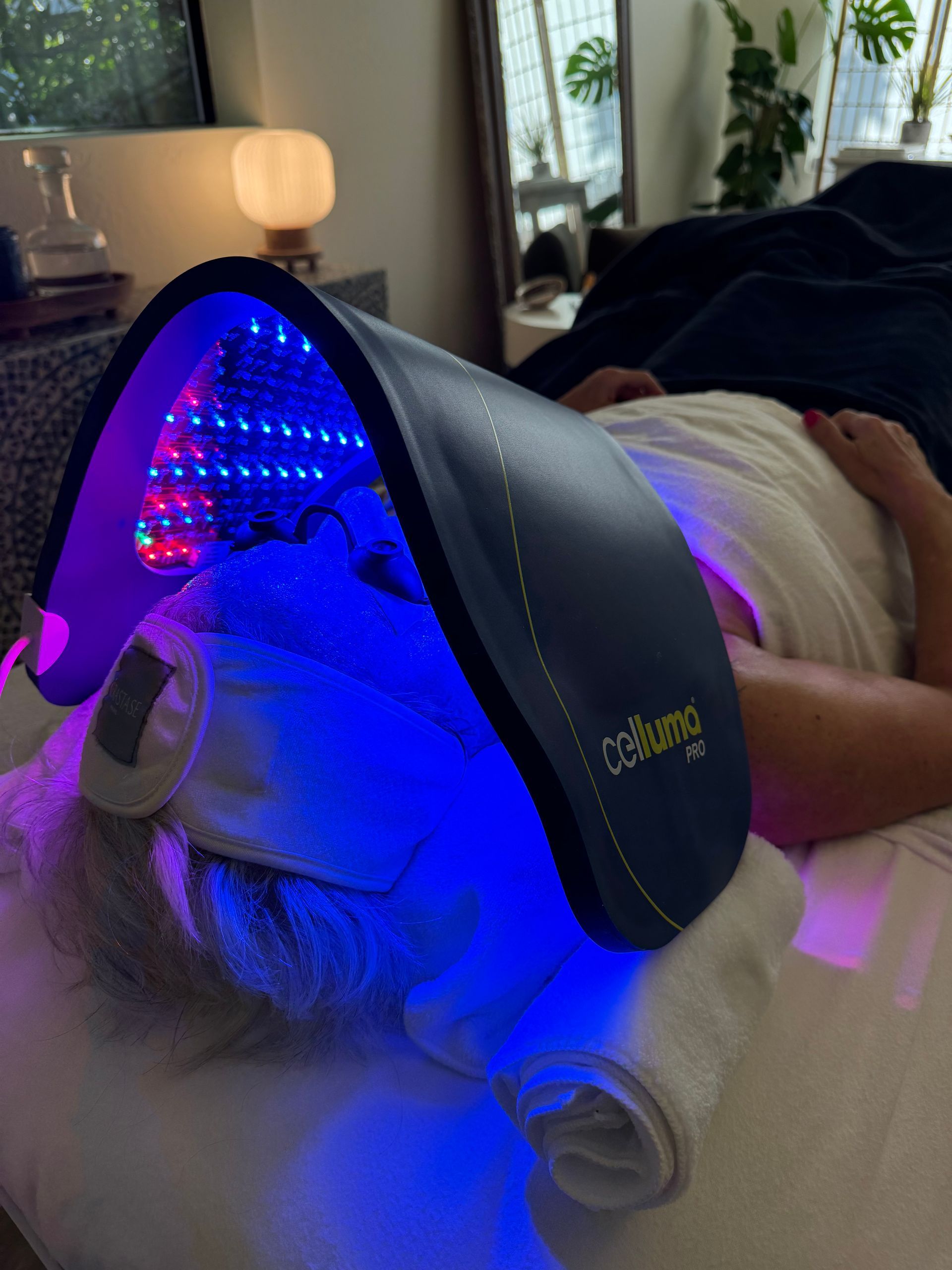 A person is laying on a bed under a blue light.