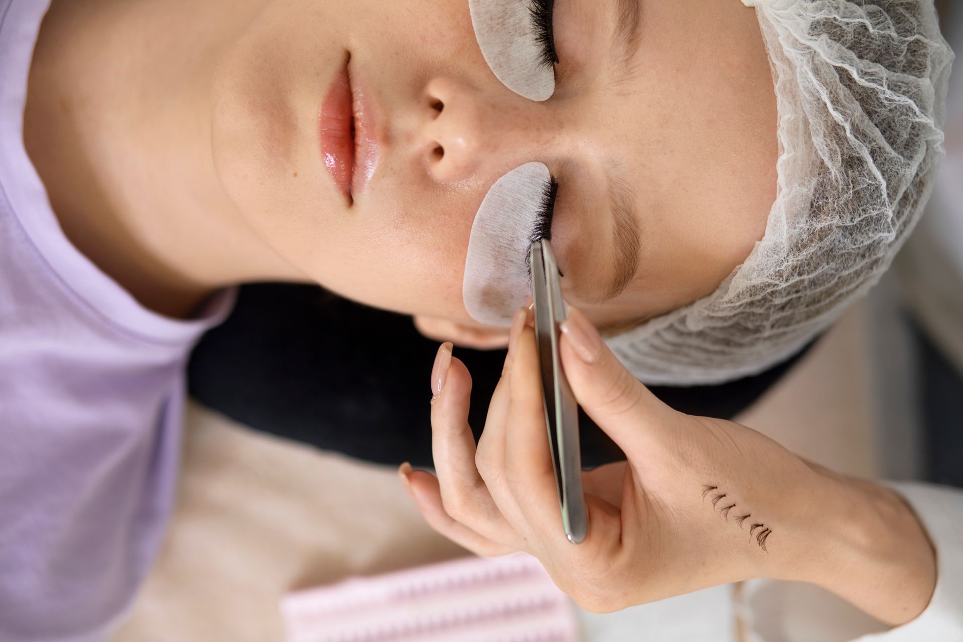 A woman is getting her eyelashes done at a beauty salon.