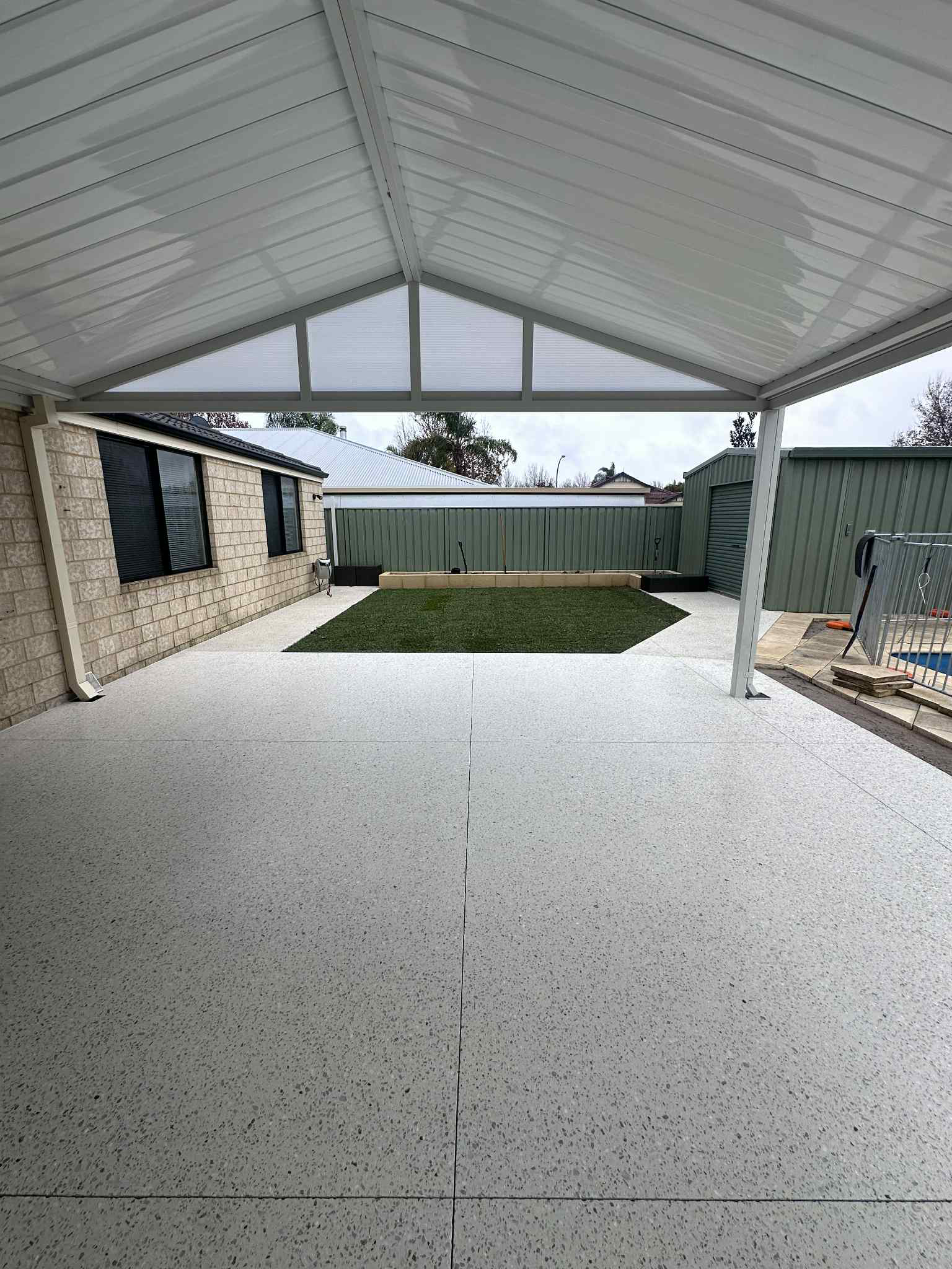 Honed concrete patio area with spa and glass fence