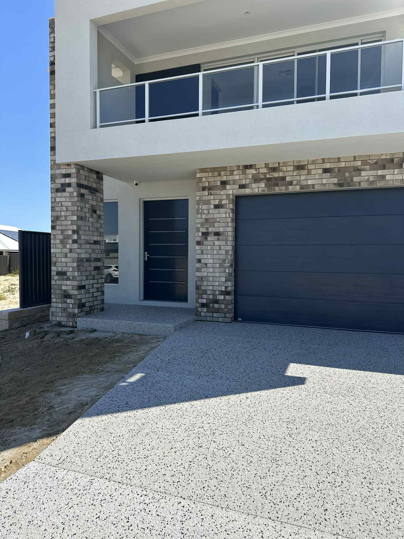 Coral exposed aggregate driveway and step up into front door