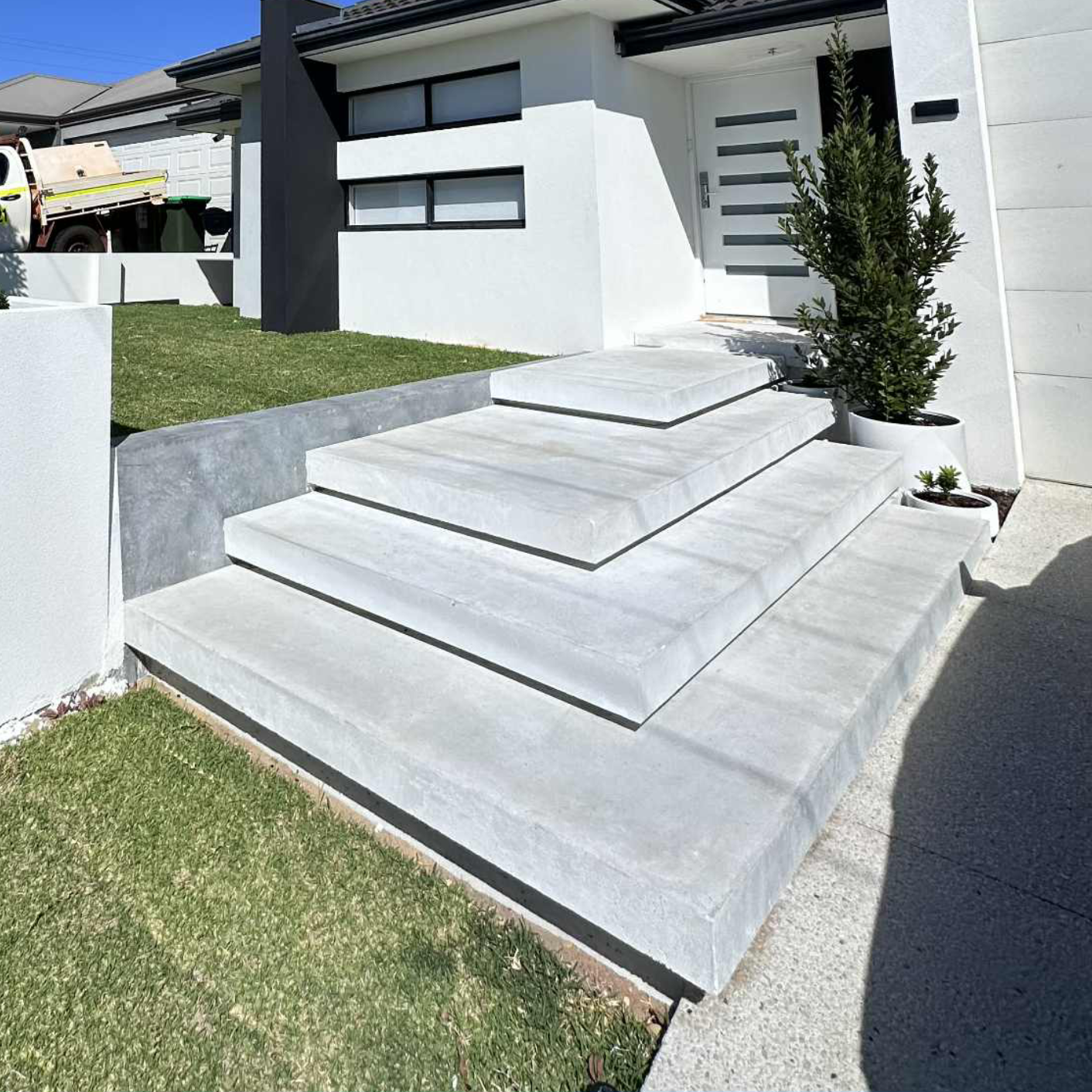 Floating concrete staircase leading into front door of Perth home