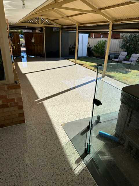 Honed concrete patio area with pool and spa with glass fence incorporated