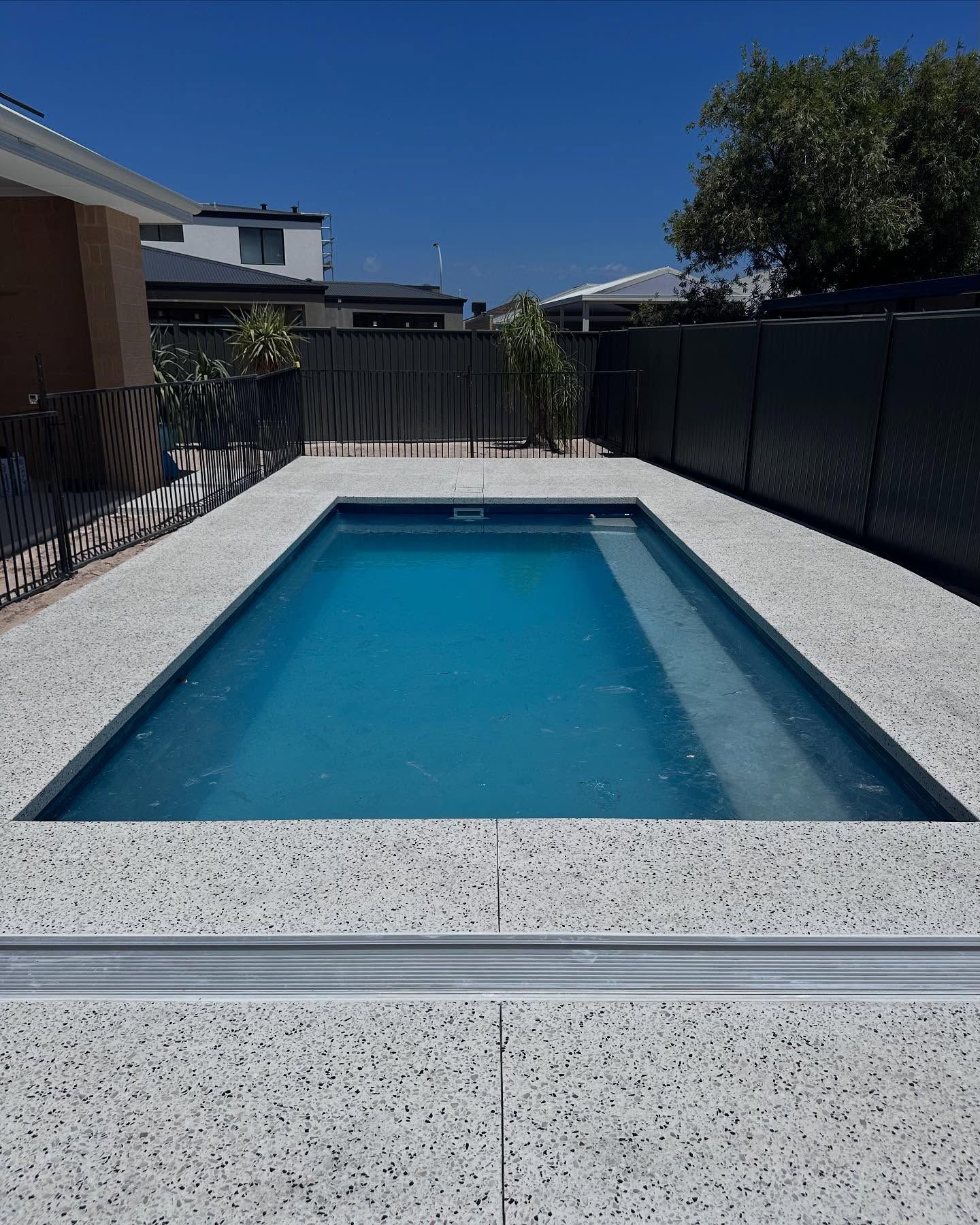 Honed concrete pool area with honed bull nose edging and inbuilt water grate