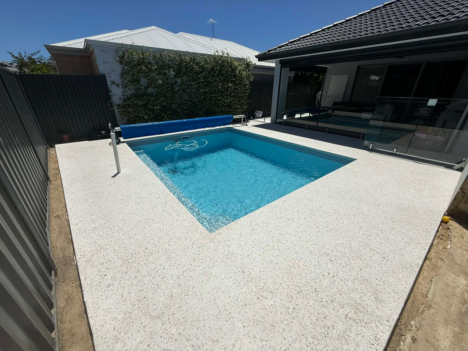 Honed concrete pool surrounds for Perth backyard with outdoor patio area 