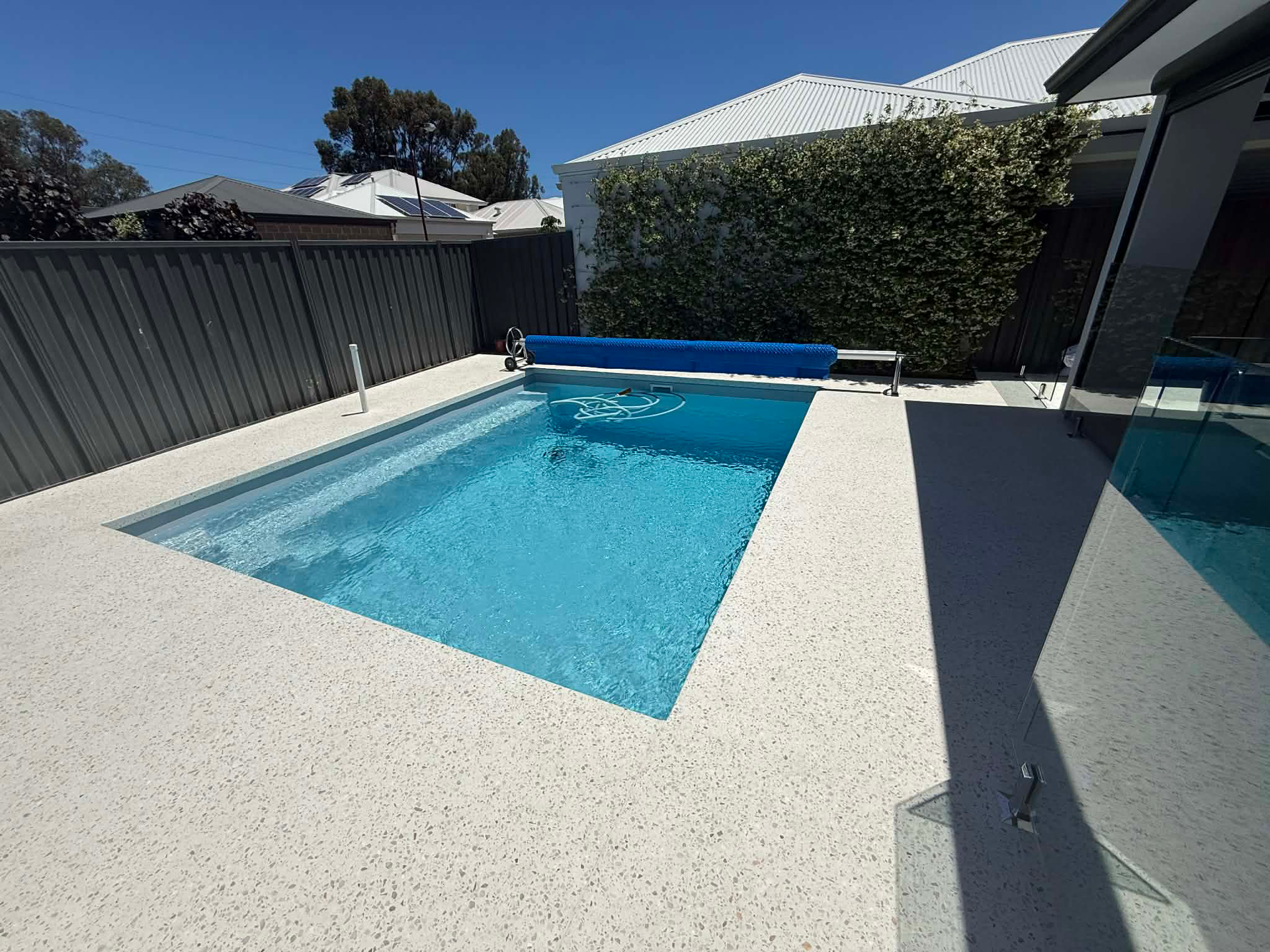 Honed concrete pool surrounds in perth backyard.