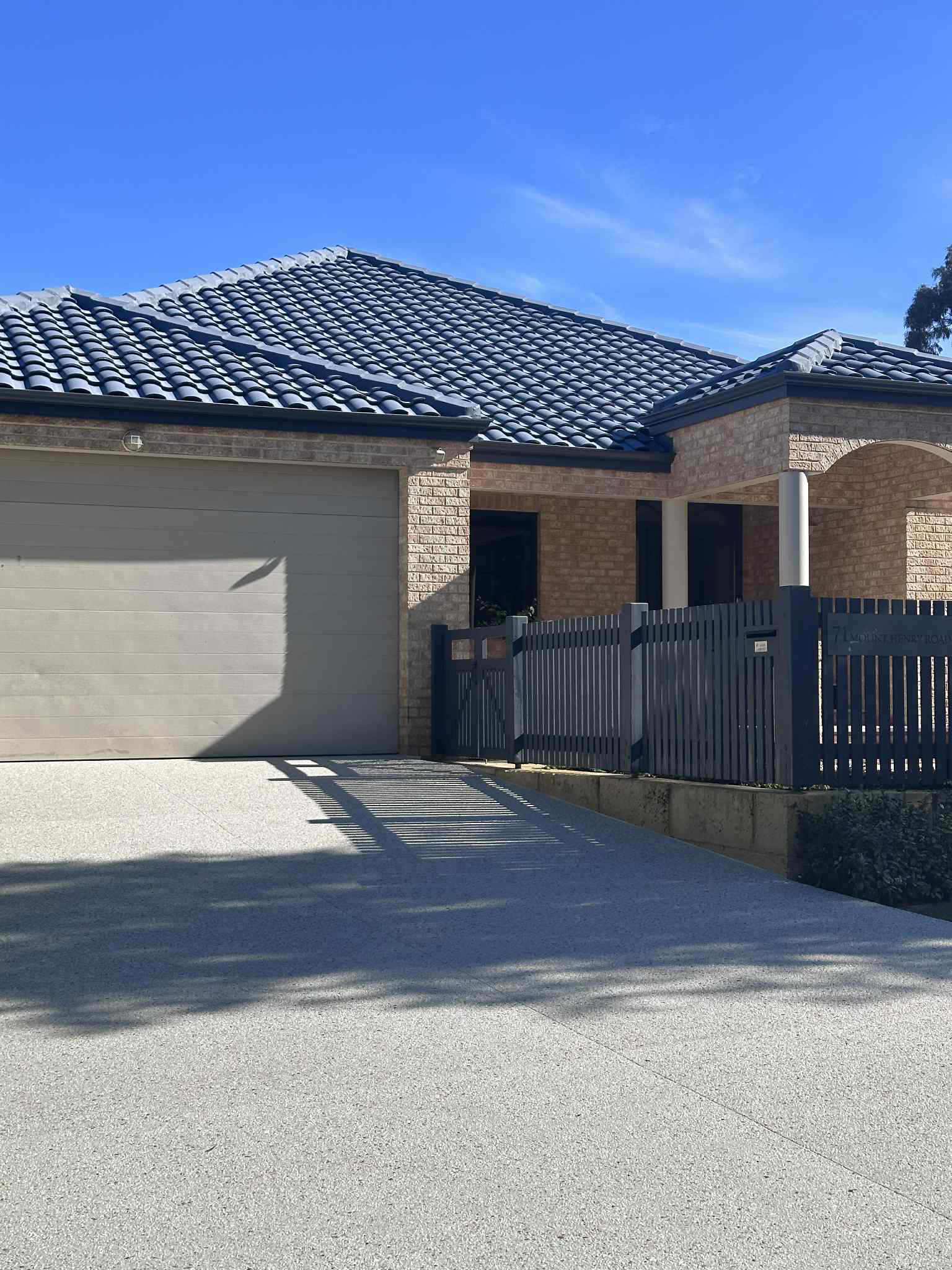 Kajani concrete mix by Limecrete poured into stunning exposed aggregate concrete driveway with limestone wall 