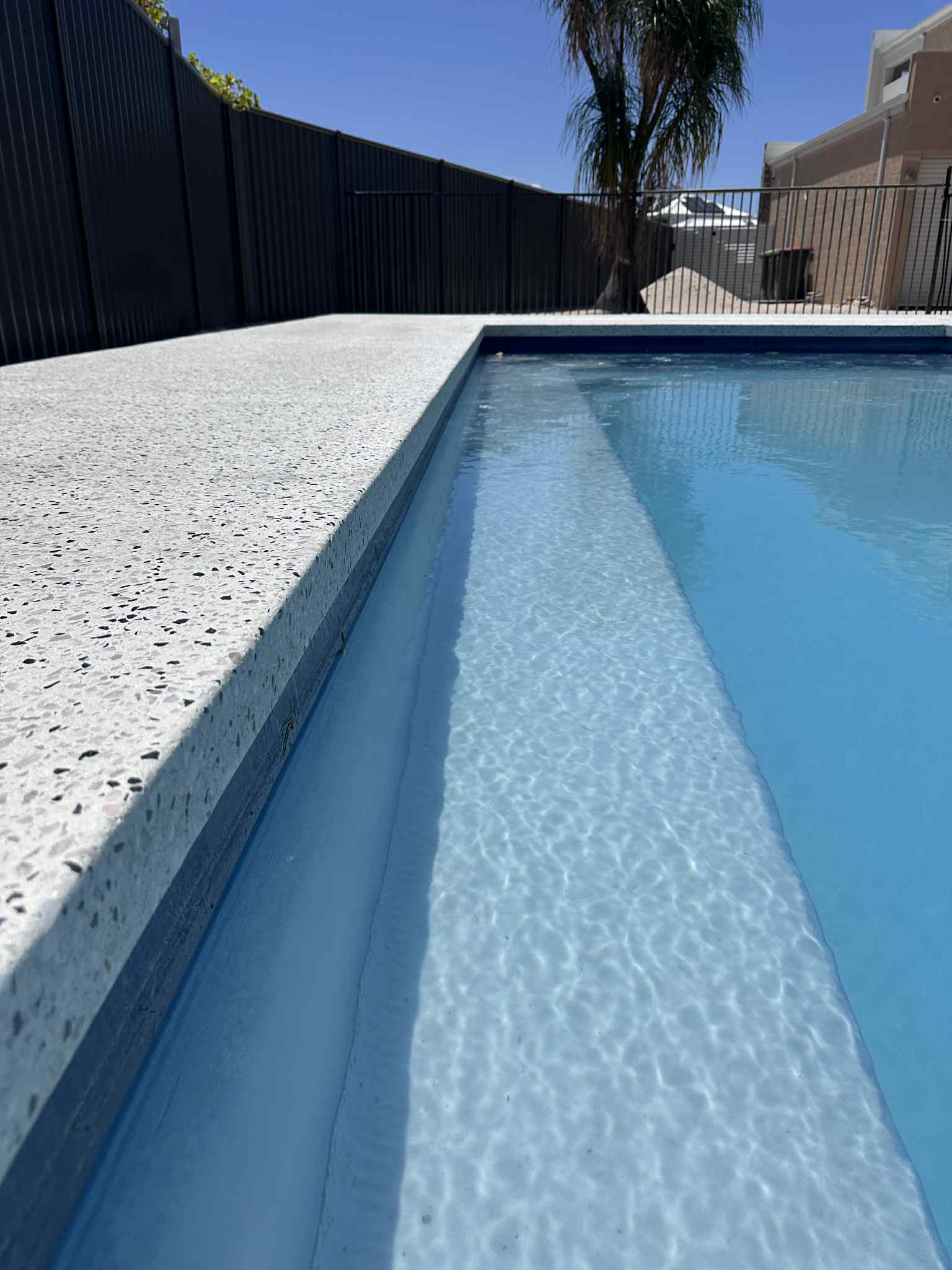 Completed concrete pool surround and alfresco area in Mindarie, showcasing a clean, modern finish by Woodlands Construction.