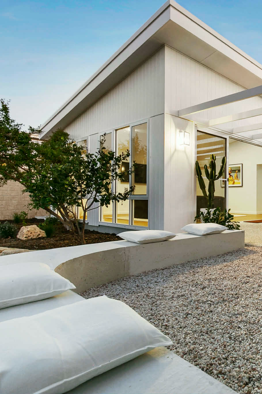 Custom off-form curved concrete bench seat built around a firepit, completed with Wattle White exposed aggregate for a seamless North Beach outdoor renovation