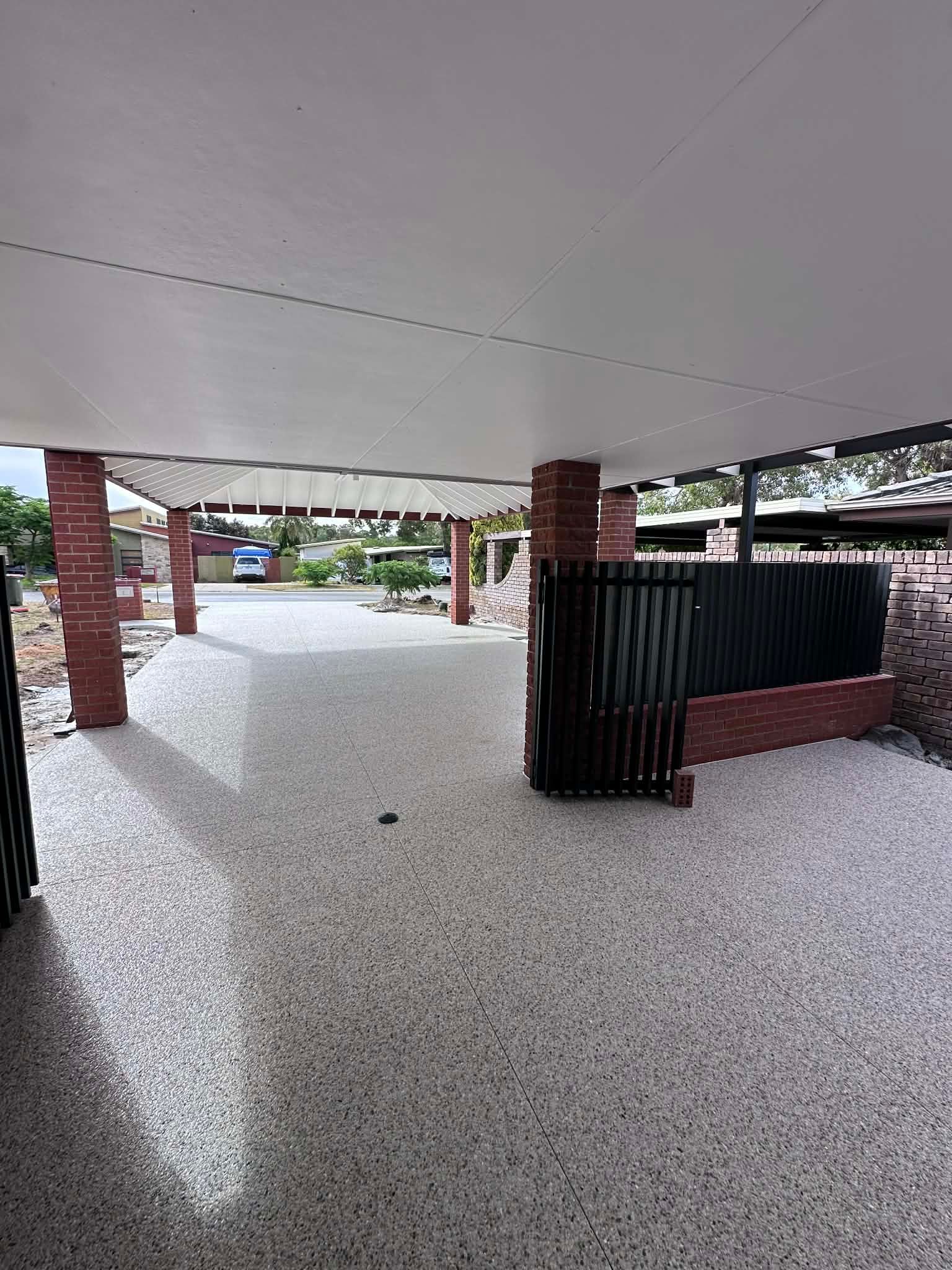 Covered outdoor area with concrete driveway and patio.