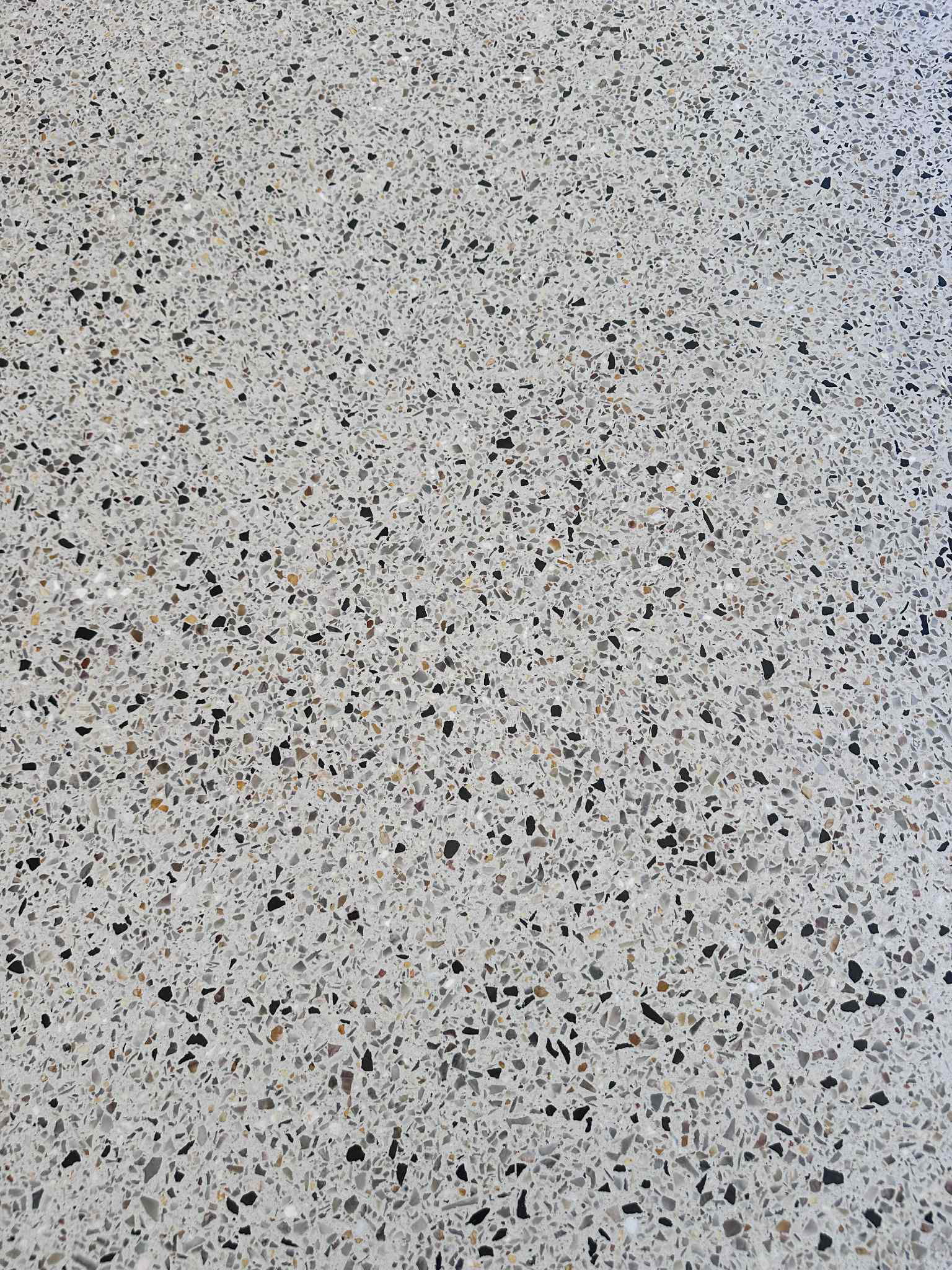 Close up of Kajaani white honed aggregate concrete floor in patio installed by Woodlands Construct