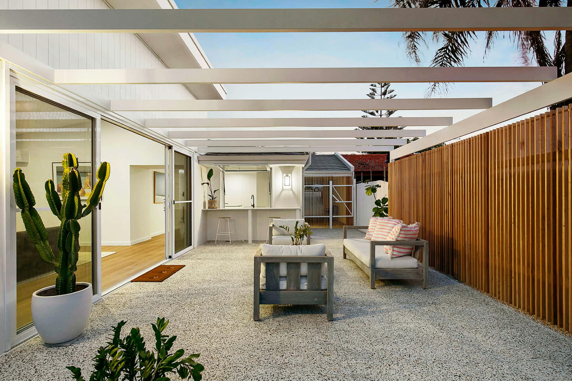 Exposed aggregate alfresco area in North Beach using Geostone Holcim Wattle White mix, creating a bright modern outdoor living space.